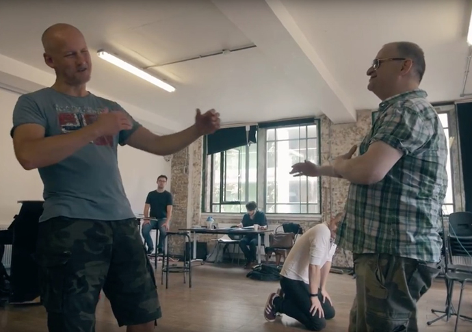 Jonathan Moore, right, rehearsing the cast of Greek