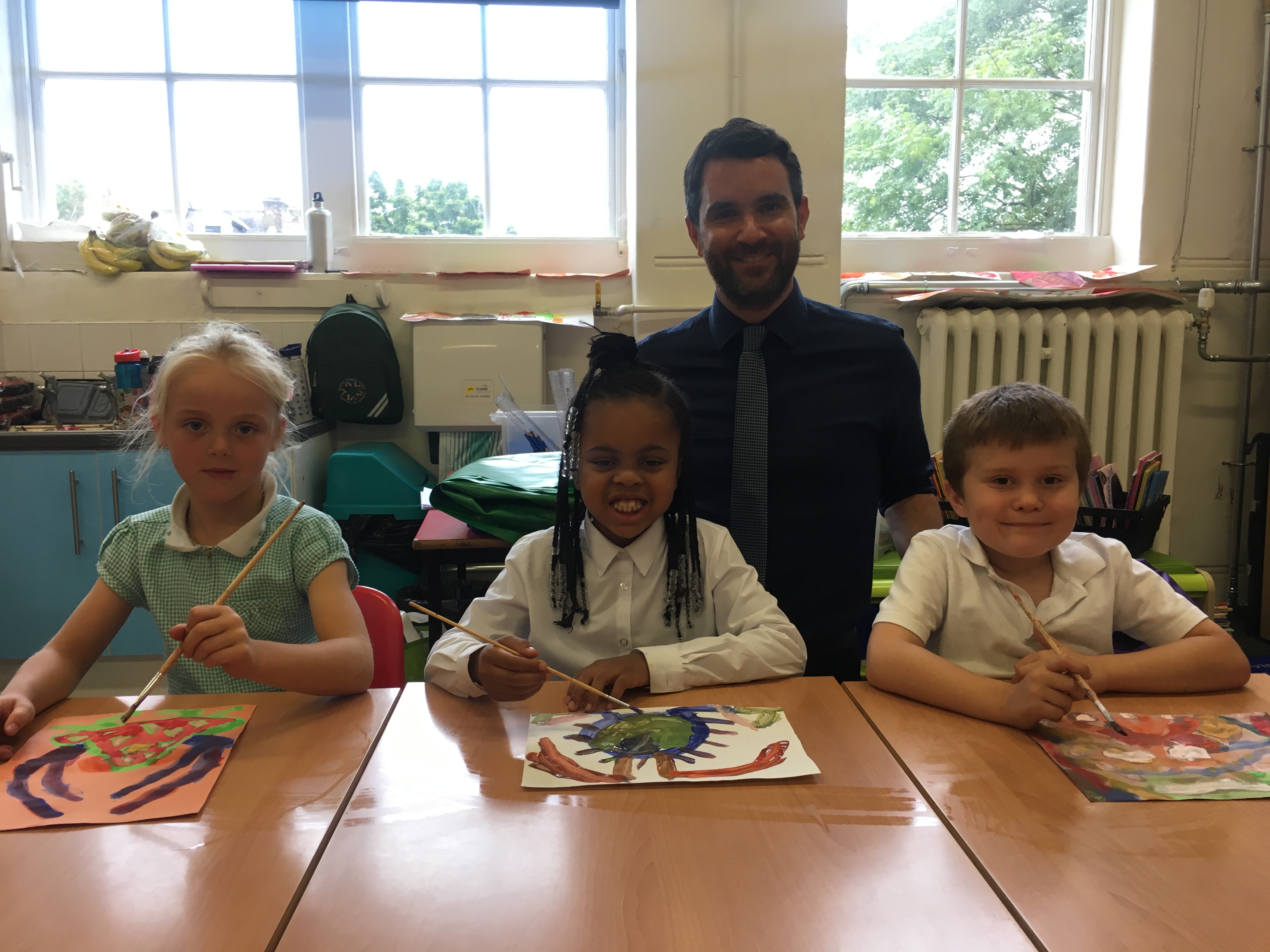 Year 2 children Quinn, Desire and Tommy with Mr Drake