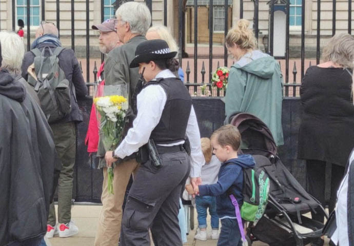 Nice happenings on a sad day Police with boy in Queen tribute queue